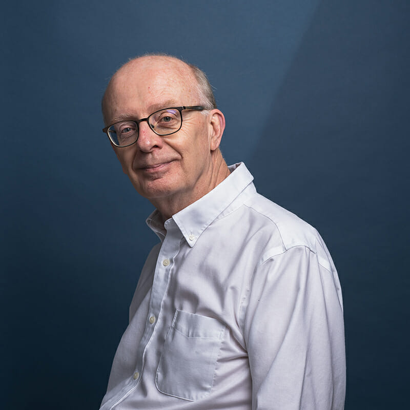 Headshot of David Spillane with blue background