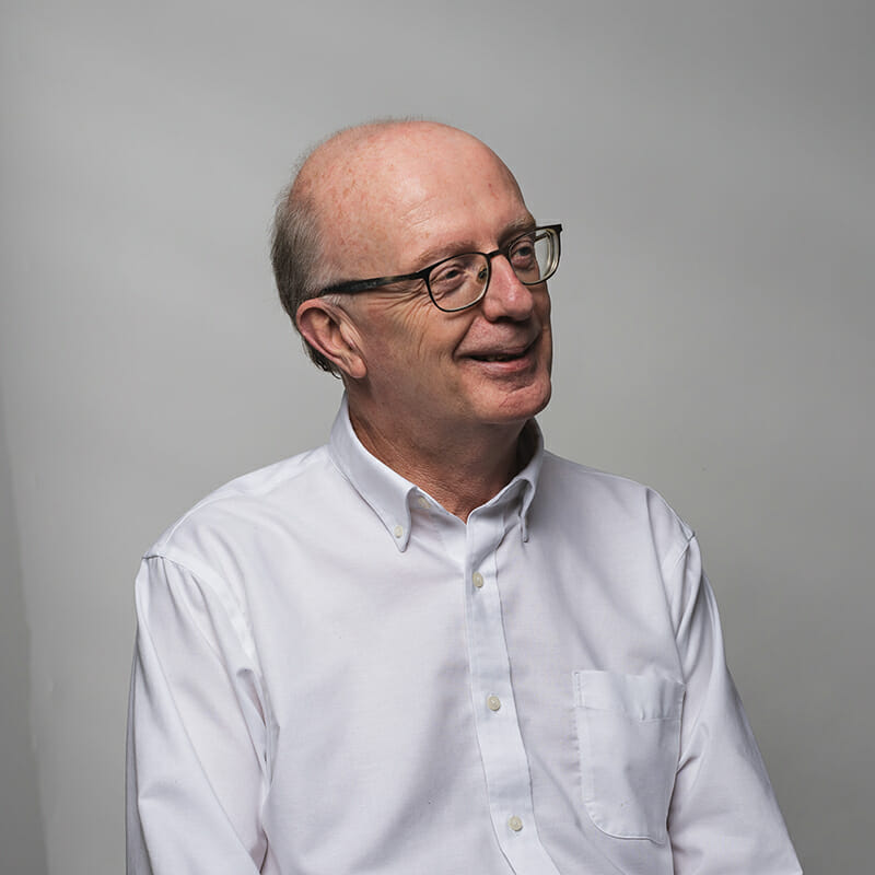 Headshot of David Spillane with dark gray background