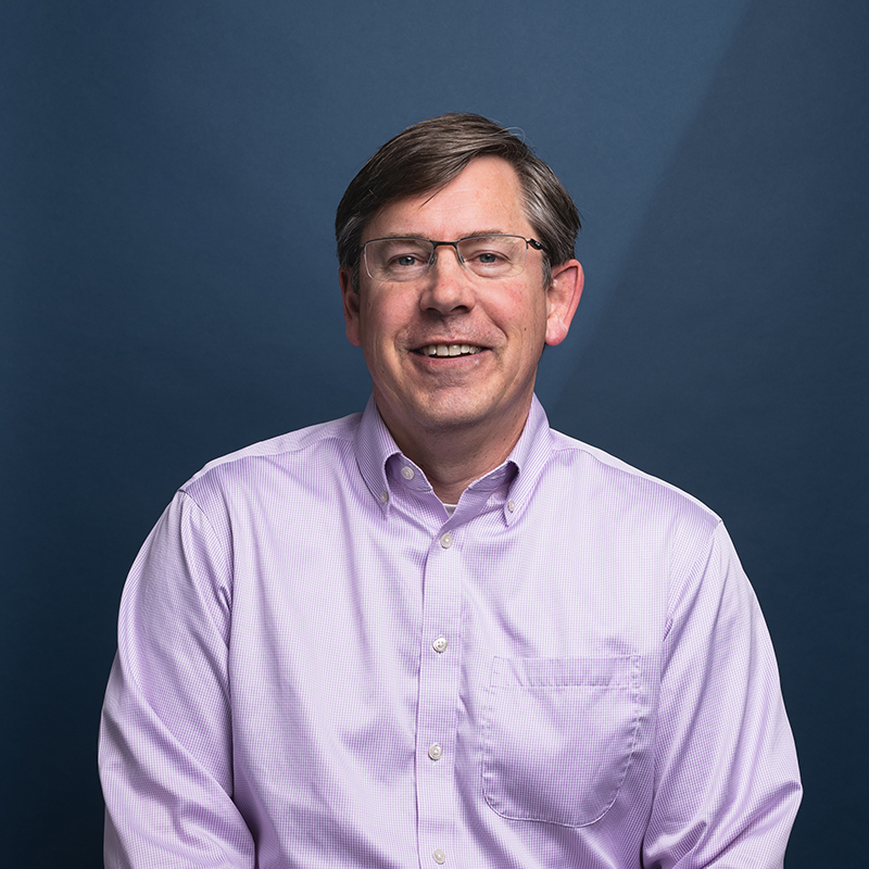 Headshot of Todd Symonds with blue background