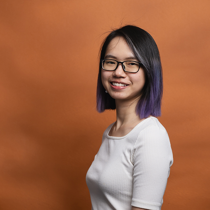 Headshot of An Hoang with orange background