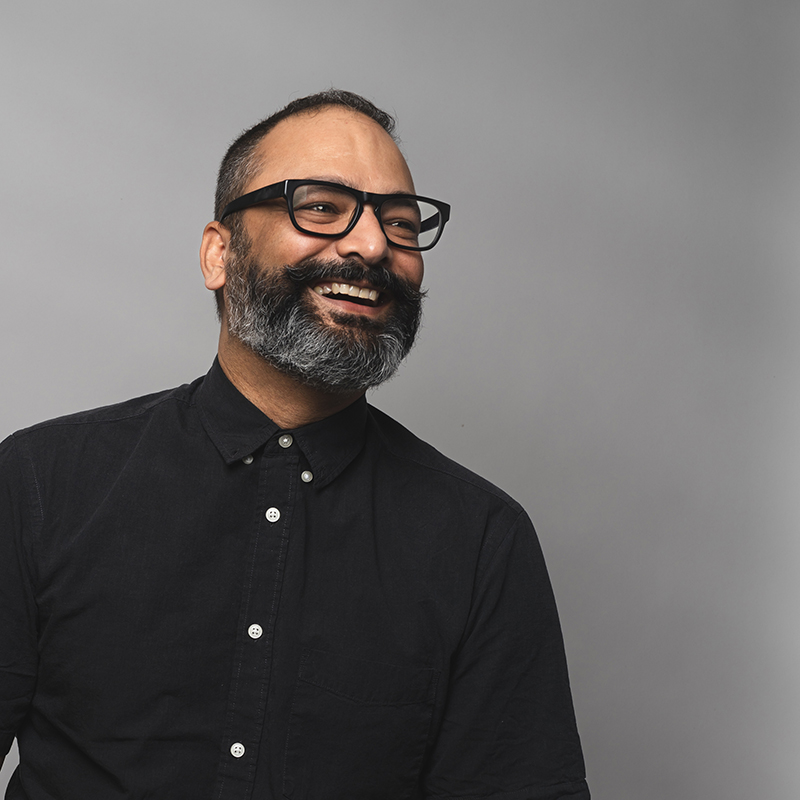 Headshot of Arjun Mande with dark gray background