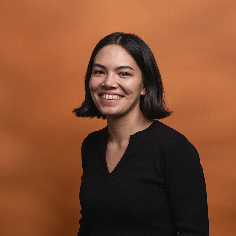 Headshot of Charly Kring with orange background