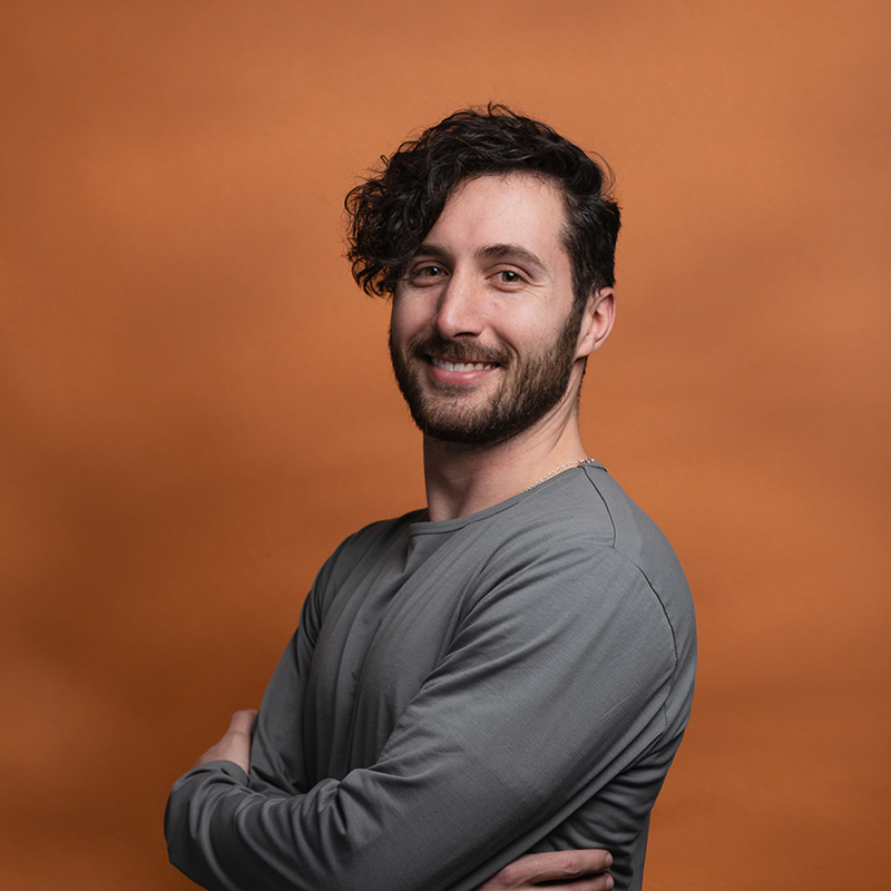 Headshot of Daniel Quartararo with orange background