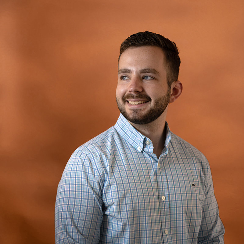 Headshot of Dominick Stanco with orange background