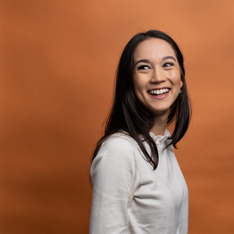 Headshot of Elisabeth Mansfield with orange background