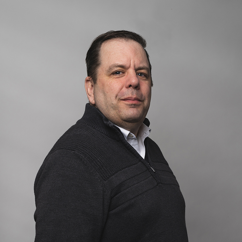 Headshot of Geoffrey Meier with dark gray background