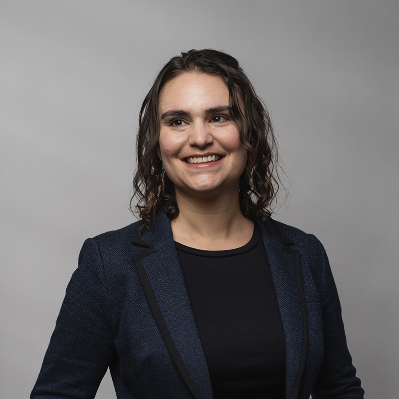 Headshot of Hannah Levine with dark gray background