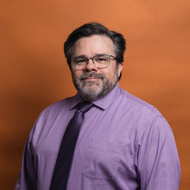 Headshot of Jim Clifford with orange background