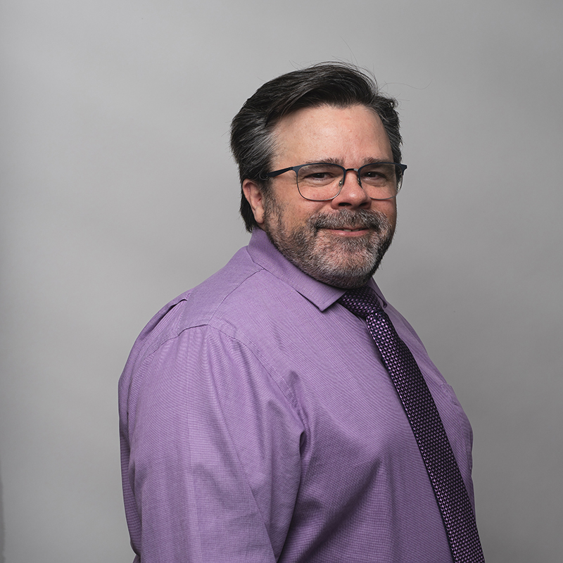 Headshot of Jim Clifford with dark gray background