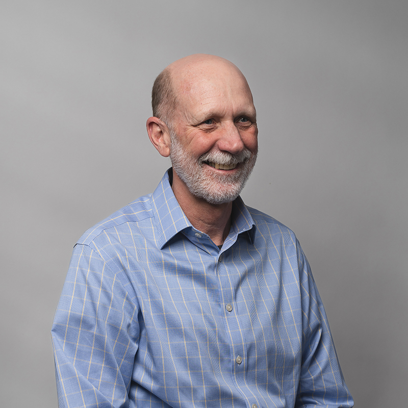 Headshot of John Benson with gray background