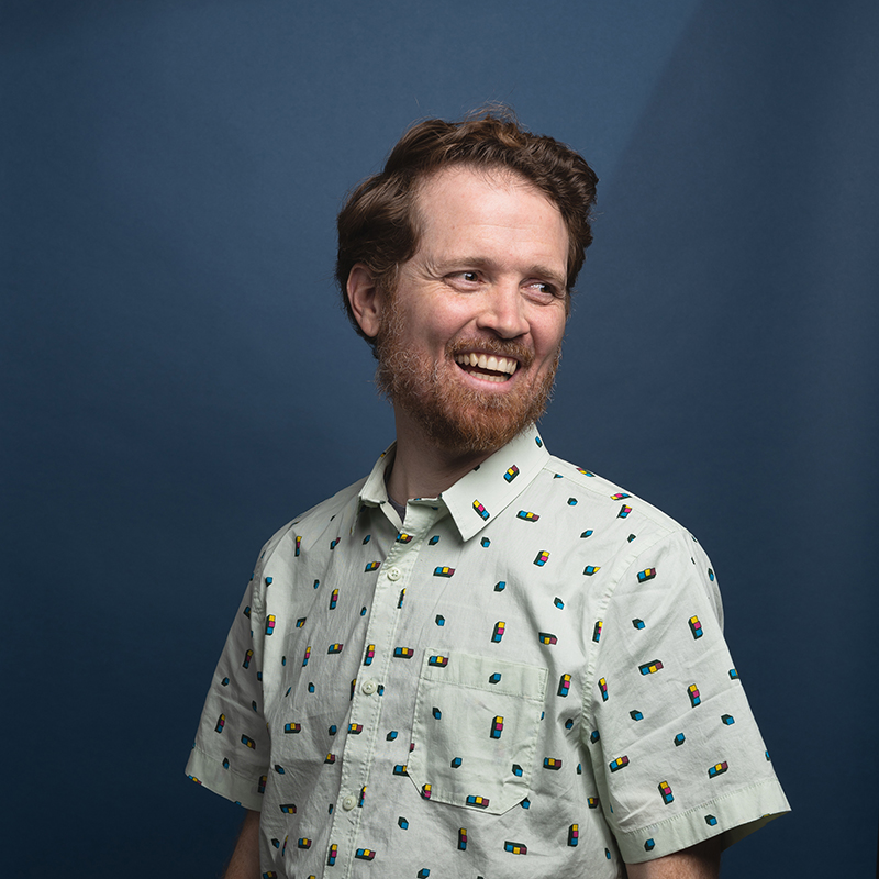 Headshot of Josh Swasey with blue background