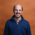 Headshot of Kevin Minster with orange background