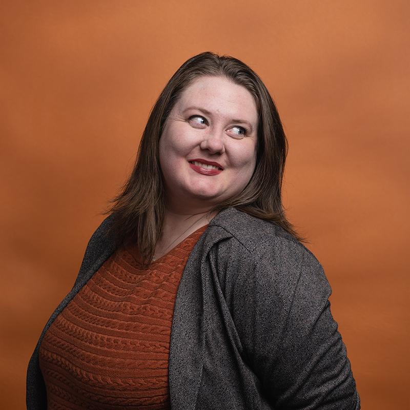 Headshot of Kristen Caulk with orange background