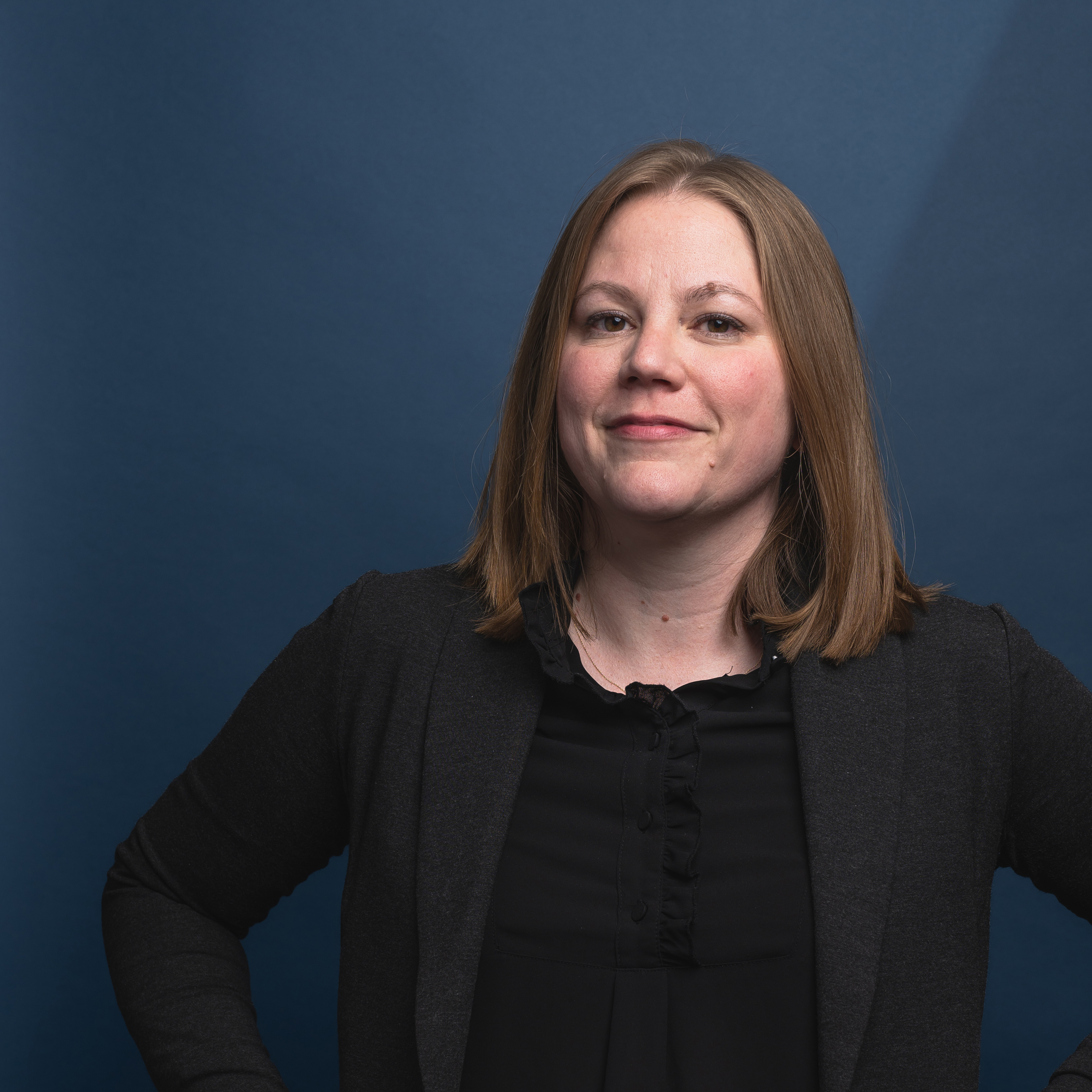 Headshot of Libby Brown with blue background