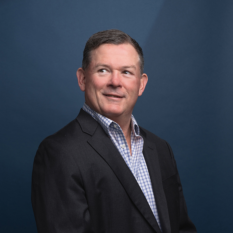 Headshot of Michael Walsh with blue background