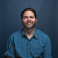 Headshot of Michael Feely with blue background