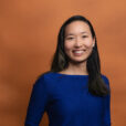 Headshot of Olivia Huang with orange background