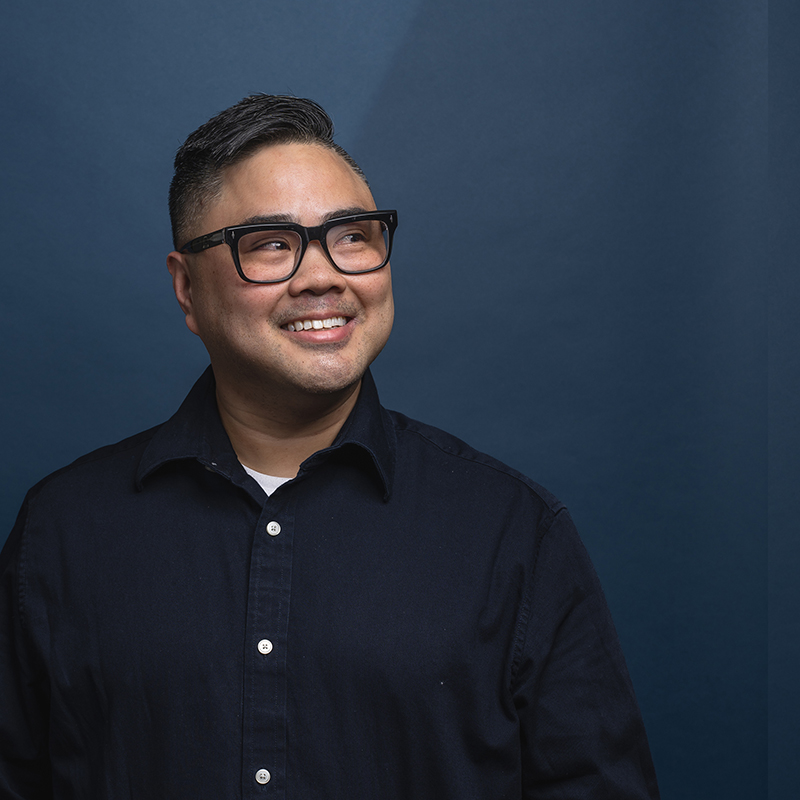 Headshot of Paul Santos with blue background