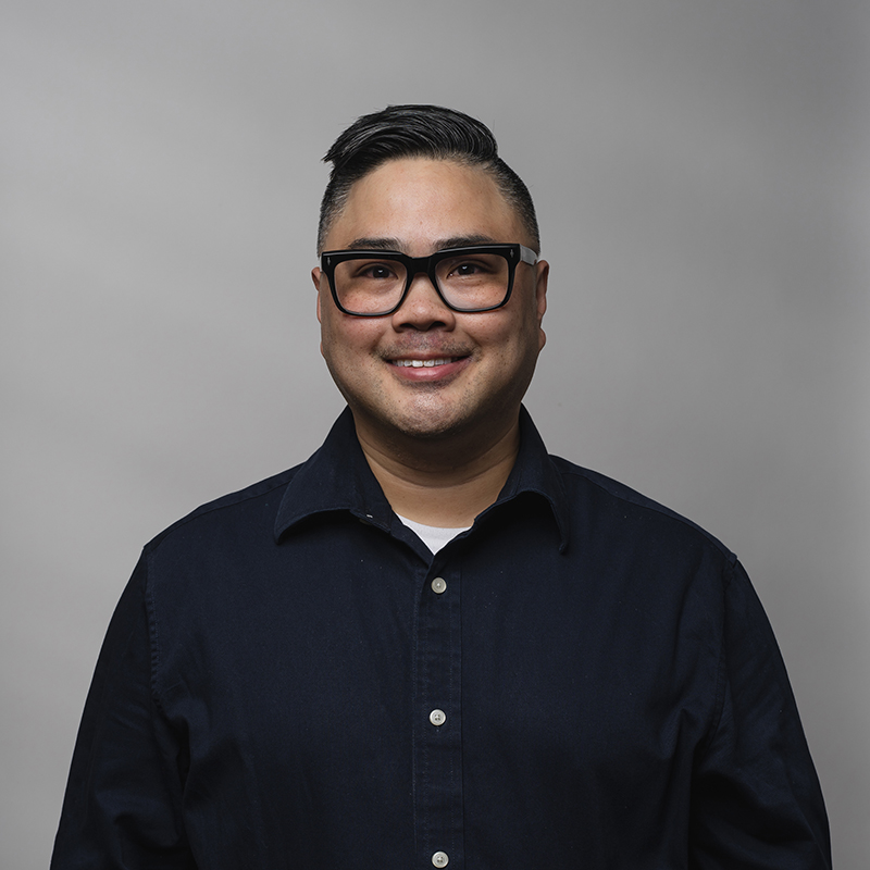 Headshot of Paul Santos with gray background