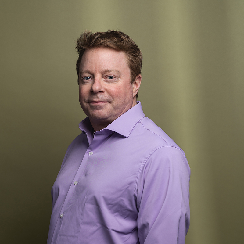 Headshot of Tim McNamara with green background