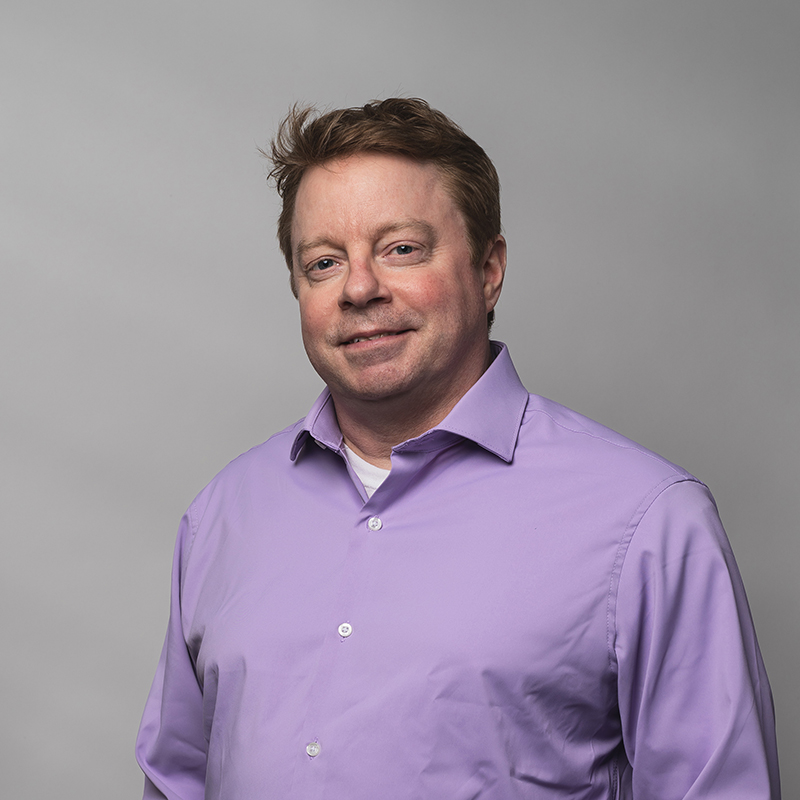 Headshot of Tim McNamara with gray background