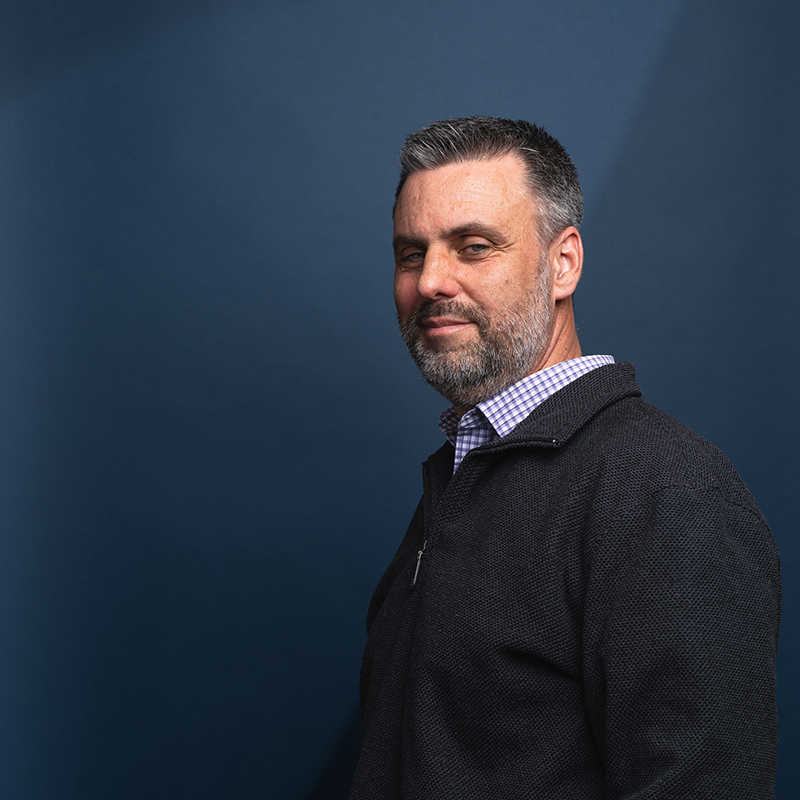 Headshot of Tom O'Brien with blue background