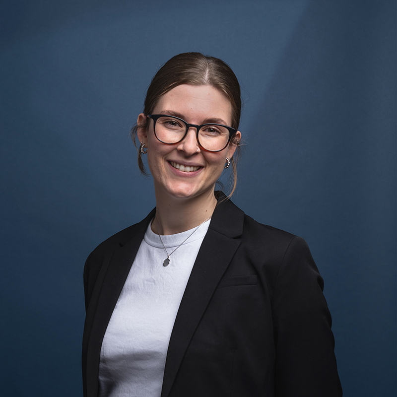 Headshot of Rachael Gerry with blue background