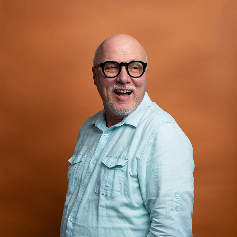 Headshot of Scott Yagel with orange background